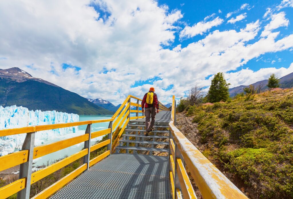 Trilha com passarela no Glaciar Perito Moreno na Patagônia Argentina com turista caminhando e vista para montanhas e lago