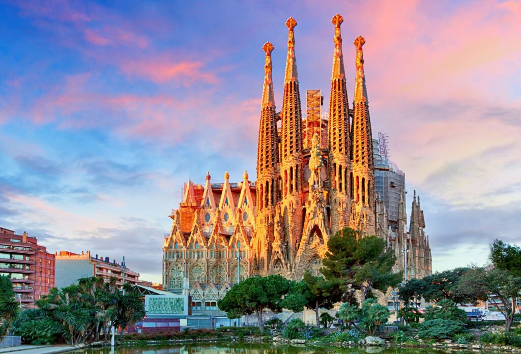 Sagrada Família em Barcelona iluminada ao entardecer, com suas torres e arquitetura de Antoni Gaudí.